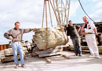 Cut field stone being lifted